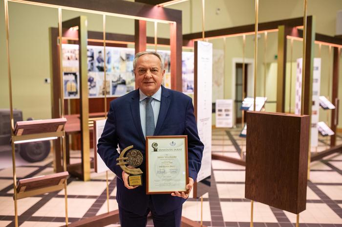 Vice President of the Management Board of Krakow Water holdig statue in one hand and diploma in other hand.