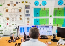 Control room. An employee in front of screens used for plant monitoring and control.