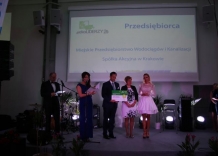On stage group of people. President of the Kraków Waterworks holds check.